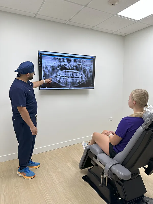 Oral surgeon showing x-ray results to young patient near Orland Park
